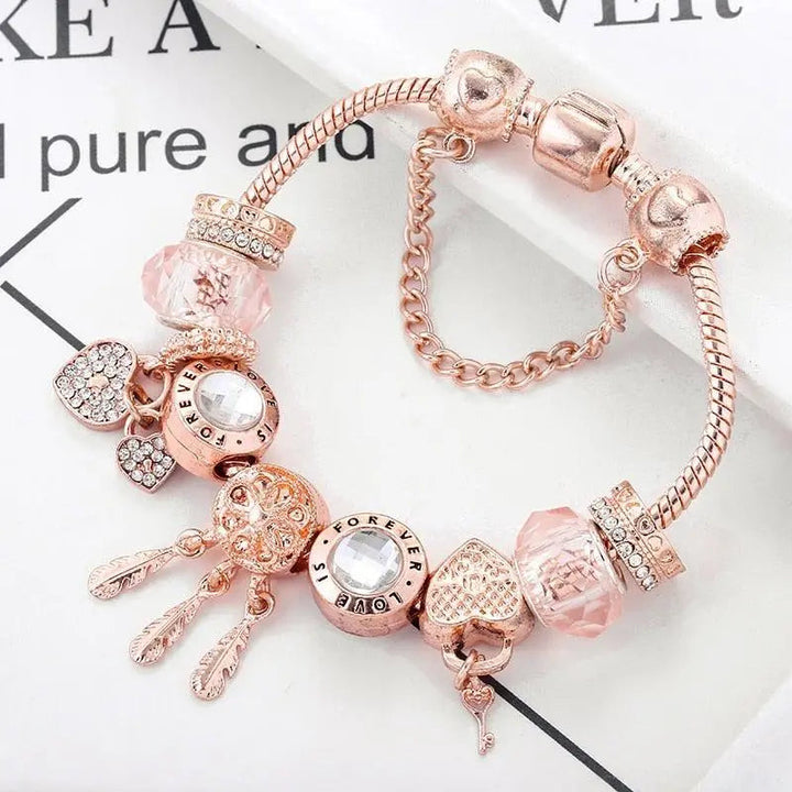 Rosa drømmefanger-armbånd med sølvcharms