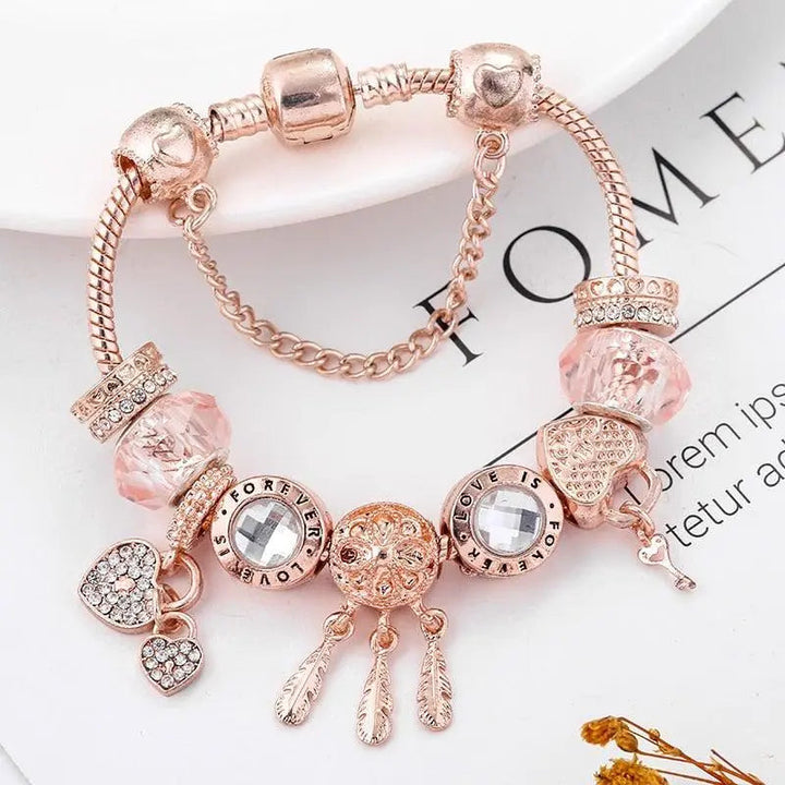 Rosa drømmefanger-armbånd med sølvcharms